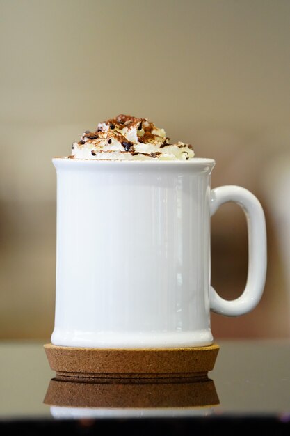 Foto taza de café con leche y crema batida en la parte superior.