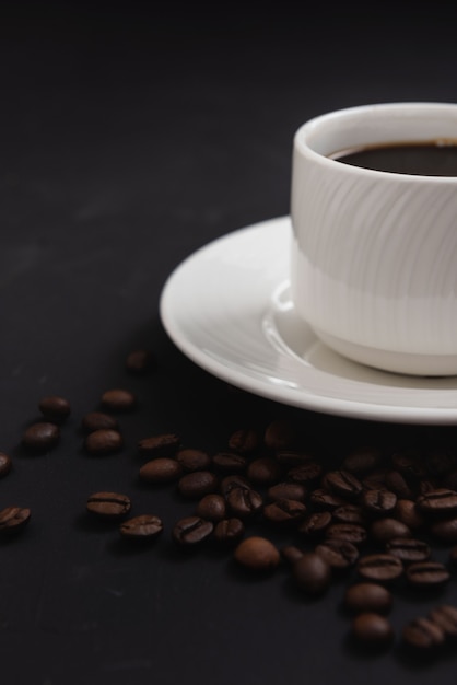 Taza de café con leche con cuchara en primer plano de fondo de café