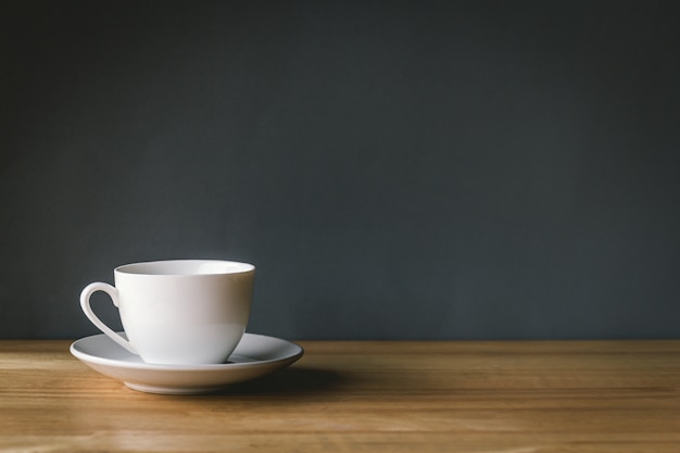 Foto taza de café con leche en el escritorio de madera con fondo gris