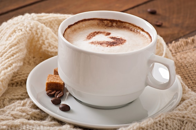 Taza de café con leche en el fondo de madera vieja