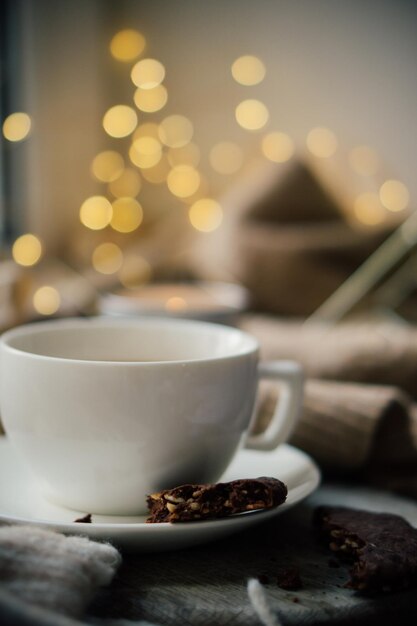 Taza de café con leche y galletas de chocolate en una cálida manta de lana acogedora casa de invierno