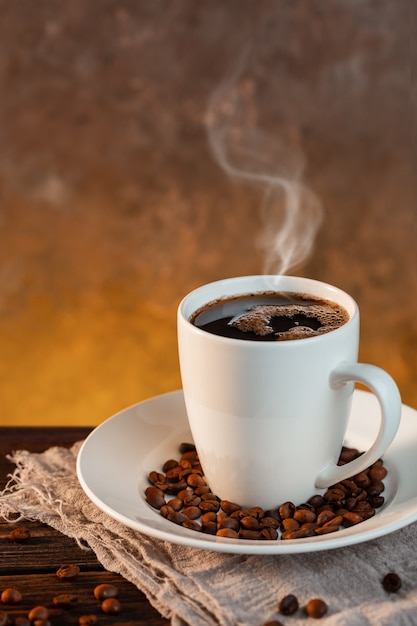 Foto taza de café con leche y granos de café