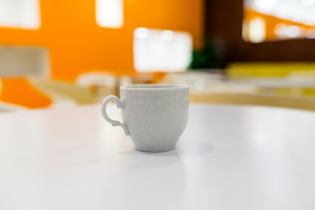 Taza de café con leche en una mesa blanca en un café