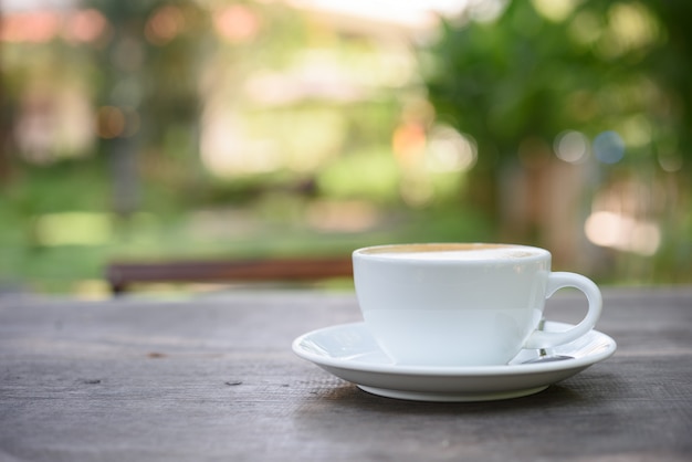 Taza de café con leche en la mesa de madera