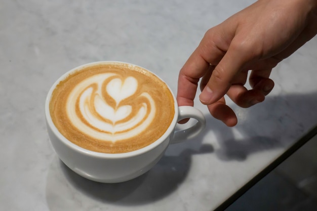 Una taza de café con leche en la mesa.