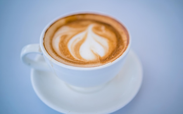 Una taza de café con leche con un patrón de remolino en la espuma