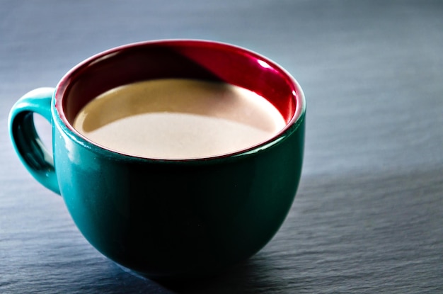 Taza de café con leche verde sobre la mesa. Desayuno.