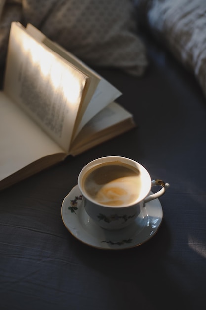 Foto una taza de café y un libro en la cama café en un acogedor interior del hogar concepto de estilo de vida de fondo