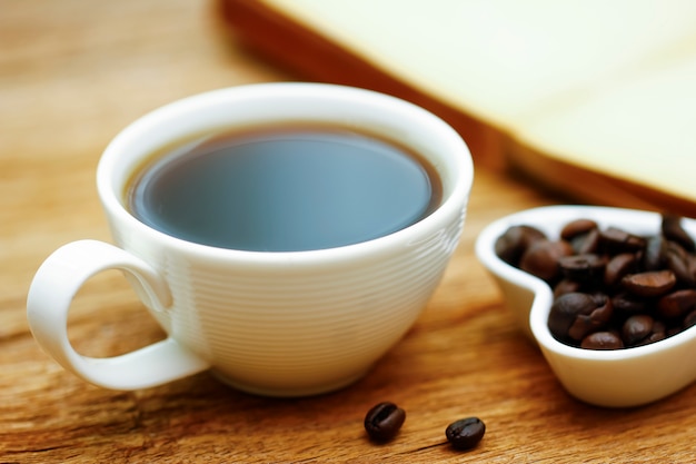 Taza de café y libro en la mesa de madera