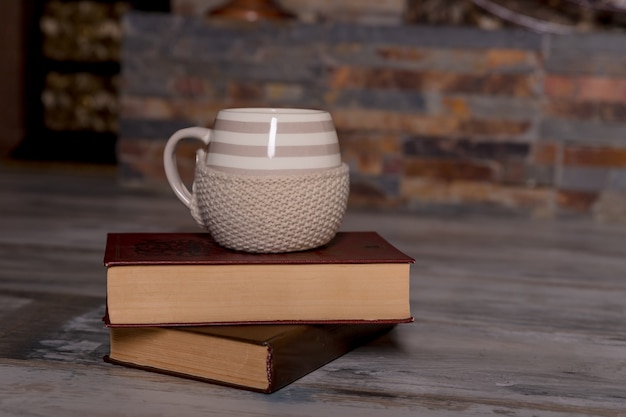 Taza de café y un libro sobre la mesa de madera en el fondo de la naturaleza