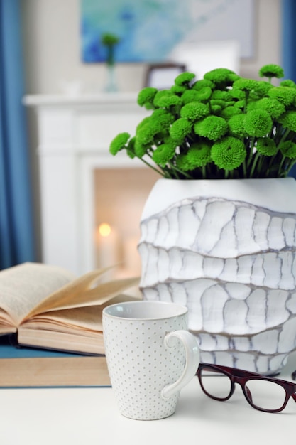 Taza de café con libros sobre la mesa en la habitación