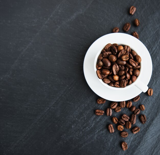 Taza de café llena de granos de café