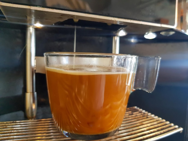 taza de café llena por máquina con cubierta de crema y vapor caliente