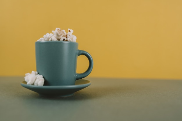 Foto taza de café llena de palomitas de maíz