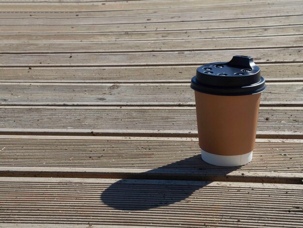 Taza de café para llevar en la mesa de madera Café de la calle