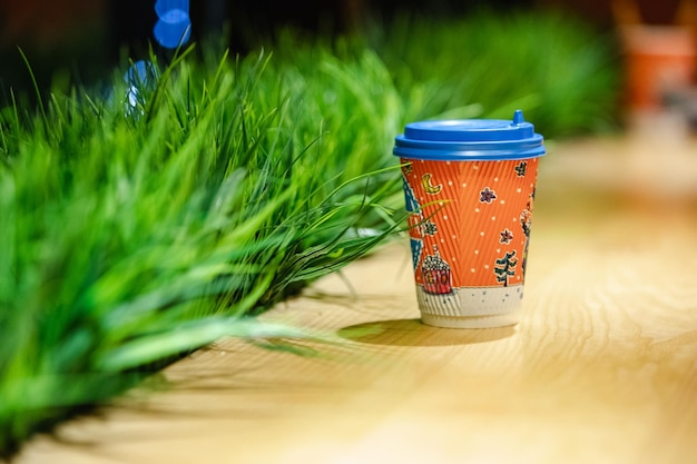 Taza de café para llevar en la mesa de madera