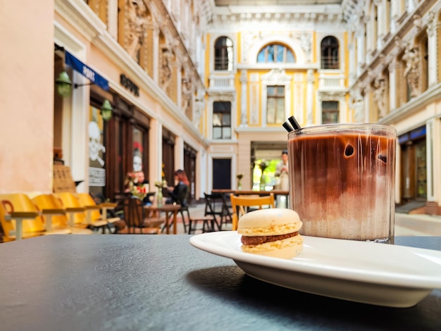 Taza de café y macaron en la mesa hermosa arquitectura en el fondo