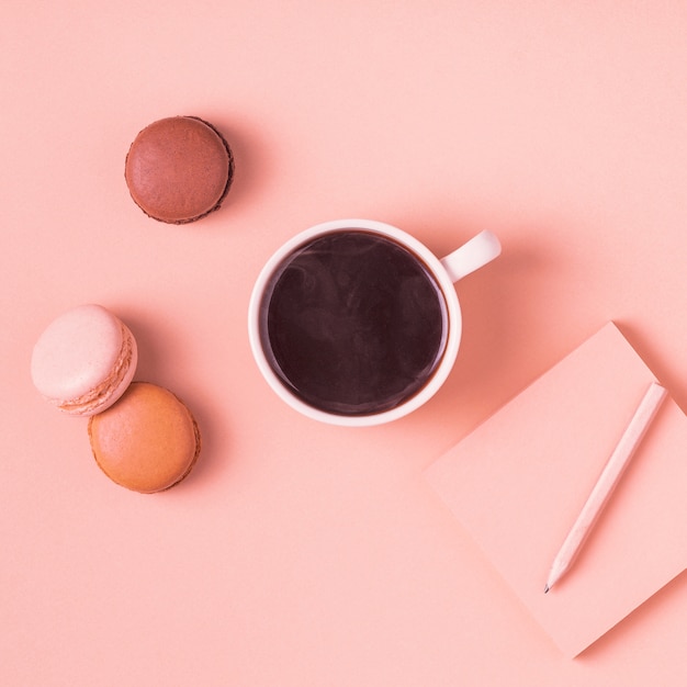 Taza de café con macarrones dulces