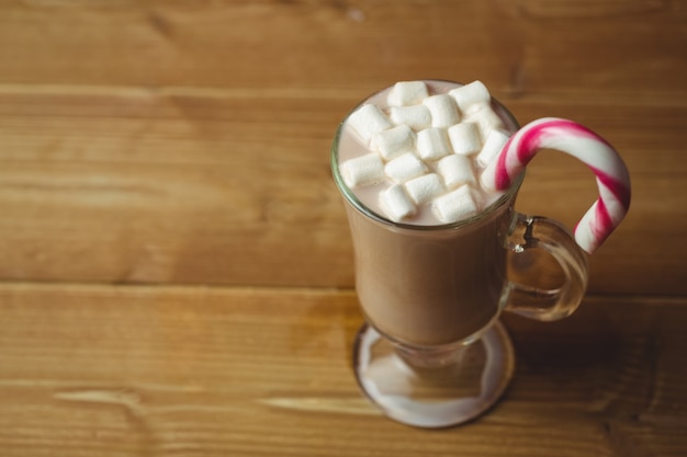 Foto taza de café con malvavisco y bastón de caramelo