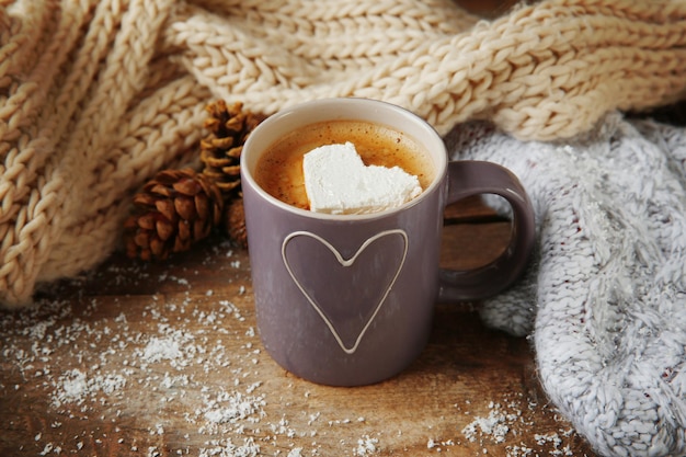 Taza de café con malvavisco en mesa de madera