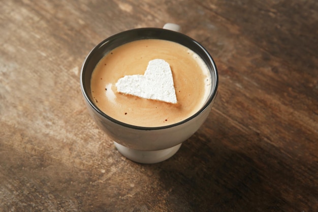 Taza de café con malvavisco en mesa de madera