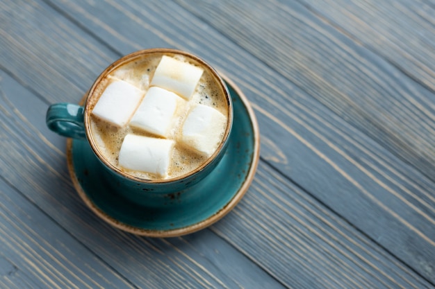 Taza de café, malvavisco sobre madera