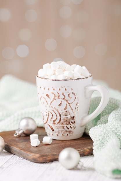 Taza con café y malvavisco, suéter, canela