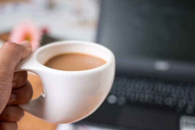 Taza de café de la mañana y computadora portátil para trabajar