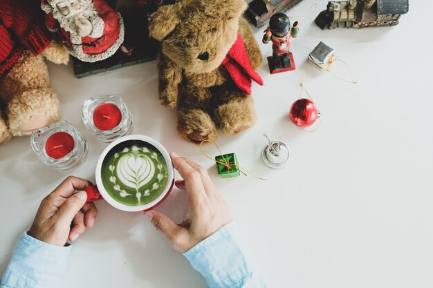 Taza de café en la mano, colocada sobre la mesa.