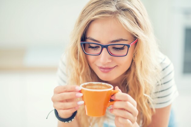 Taza de café en mano de mujer joven feliz.