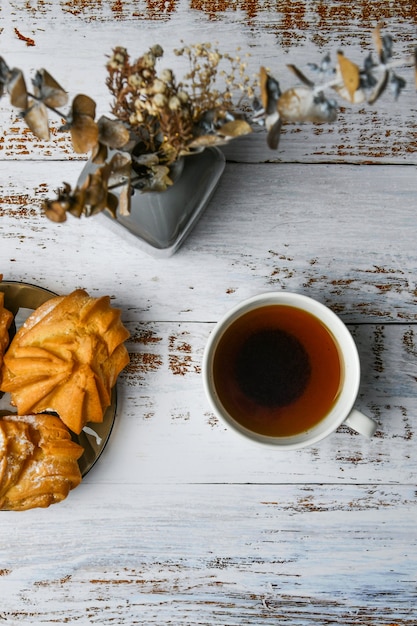 Taza de café y masa cremosa. Taza de composición de café y pastelería. Taza de café y pastelería dulce con relleno de crema sobre un fondo claro