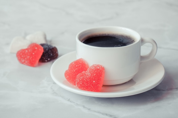 Taza de café con mermelada en forma de corazón sobre un fondo de mármol. Copia spase.