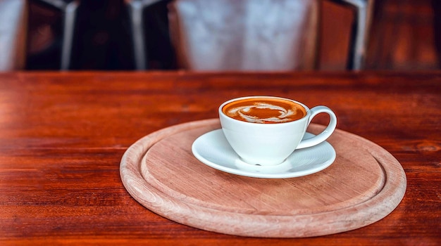 Una taza de café en la mesa de madera en la cafetería.