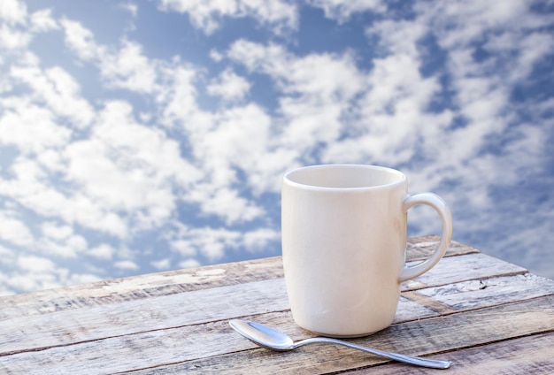 Taza de café en la mesa de madera con fondo borroso