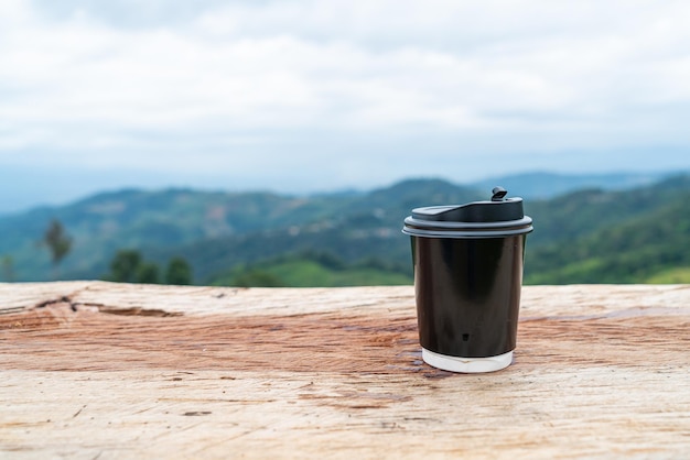 Taza de café en la mesa de madera con fondo Mountain Hill View