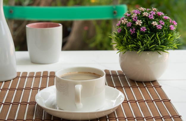 Taza de café en mesa de madera en la mañana y jardín