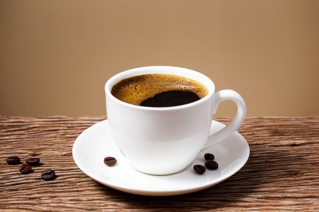 Foto taza de café en la mesa de madera vieja con pared de crema