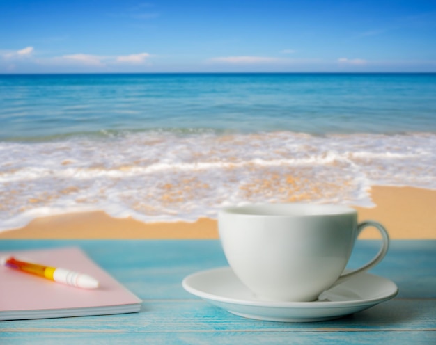 Foto taza de café en la mesa por el mar contra el cielo
