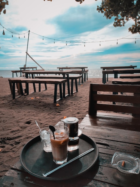 Foto taza de café en la mesa por el mar contra el cielo