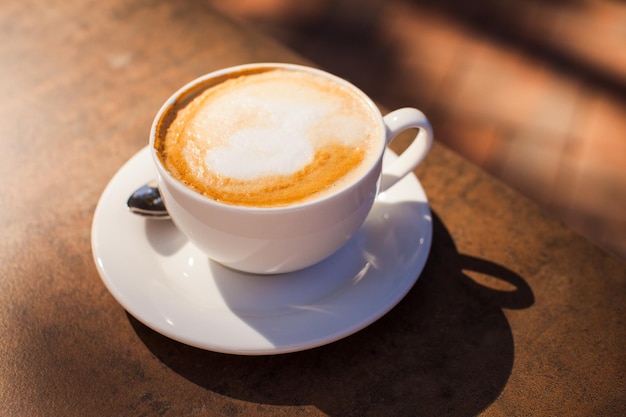 La taza de café en la mesa de mármol al aire libre, día soleado