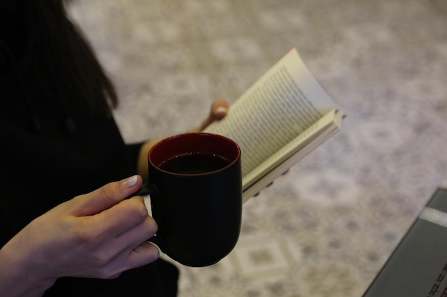 Una taza de café mientras lee un libro o una revista