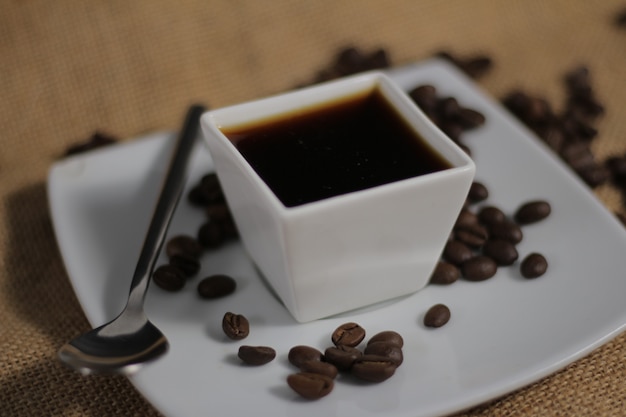 Taza de café moderna con granos de café.