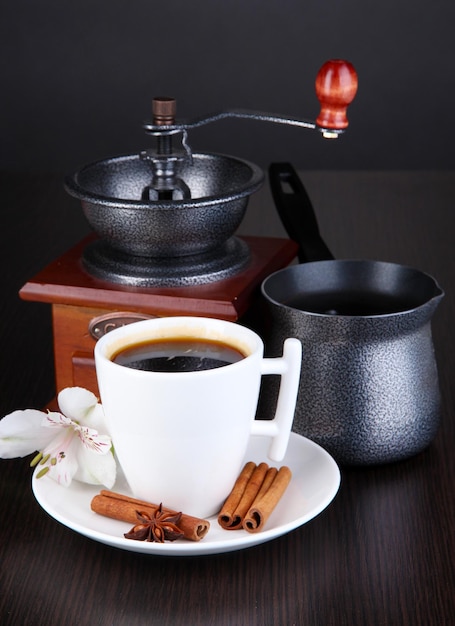 Taza de café con molinillo de café y cafetera en la mesa de madera