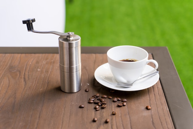 Taza de café con molinillo de café en la mesa