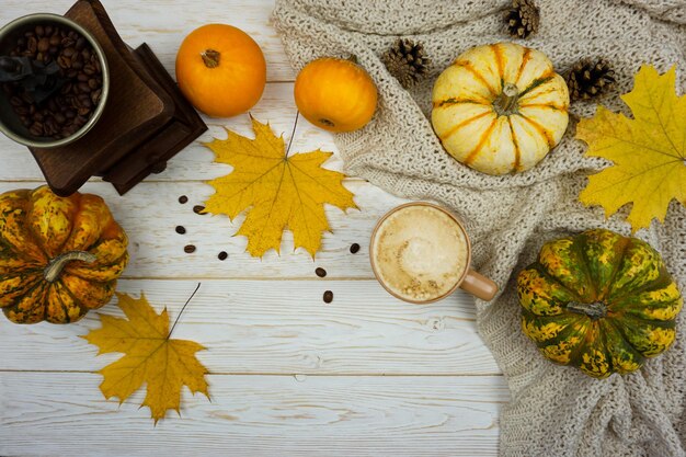 Una taza de café y un montón de calabazas en una mesa