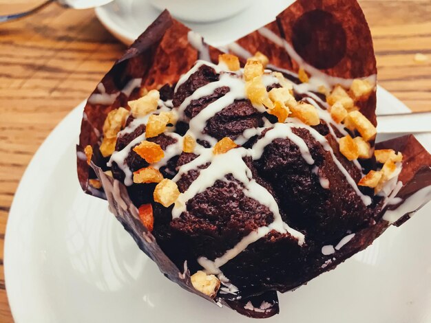 Taza de café y muffin de chocolate en la mesa de madera en el café