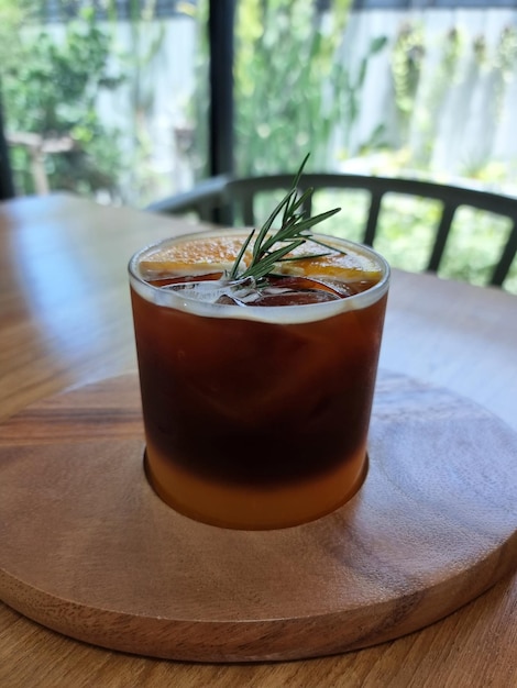 Una taza de café naranja negro sobre una mesa de madera y un fondo borroso