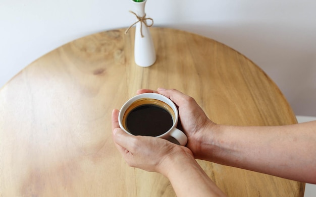 Taza de café negra en la mano