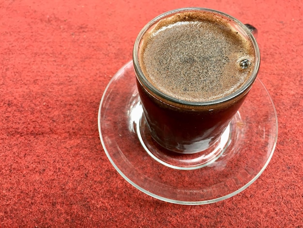 una taza de café negro en la alfombra roja