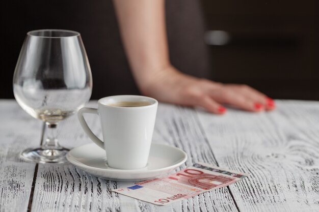 Taza de café negro y billetes en euros